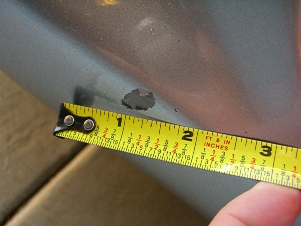 close-up of enlarging, peeling defect on lower left front bumper
