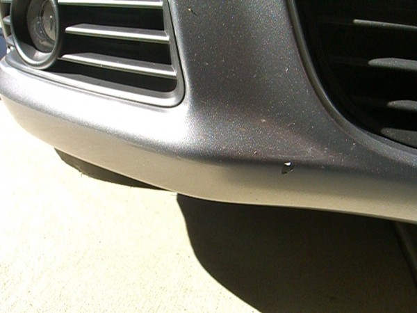 enlarging, peeling defect on lower left front bumper