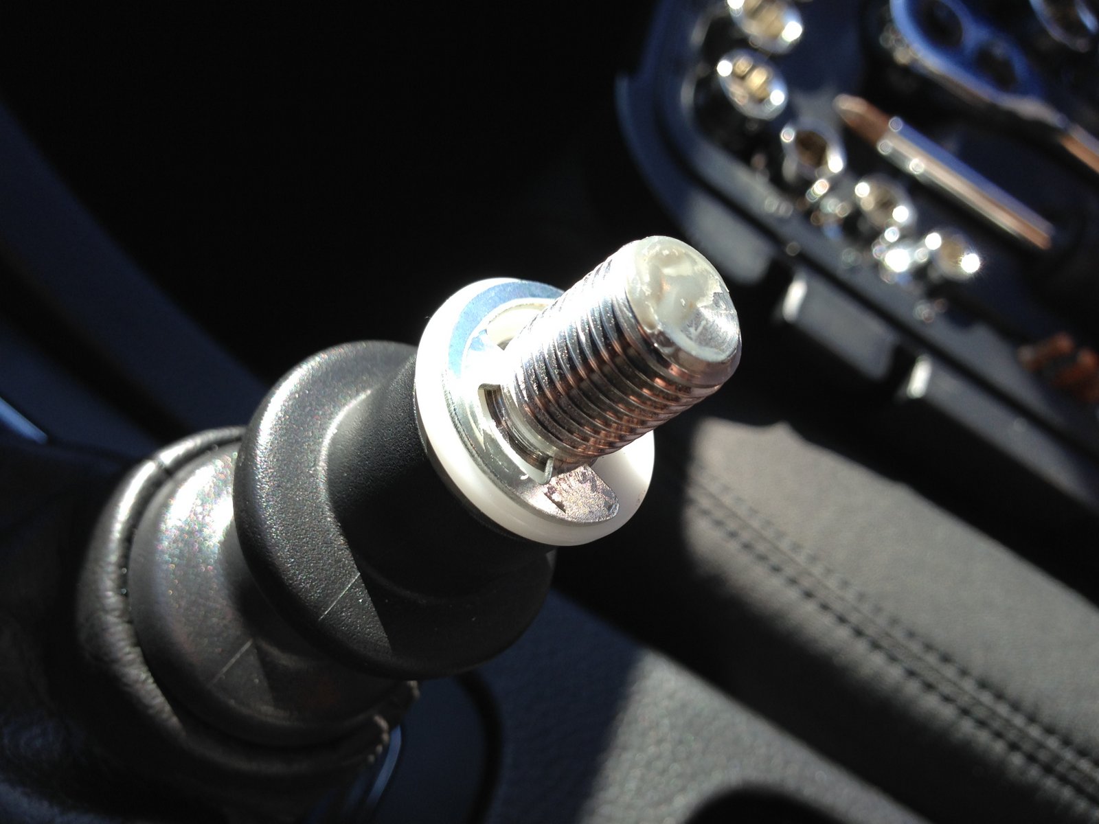 With shift knob off, carefully remove the retaining clip with a screwdriver.